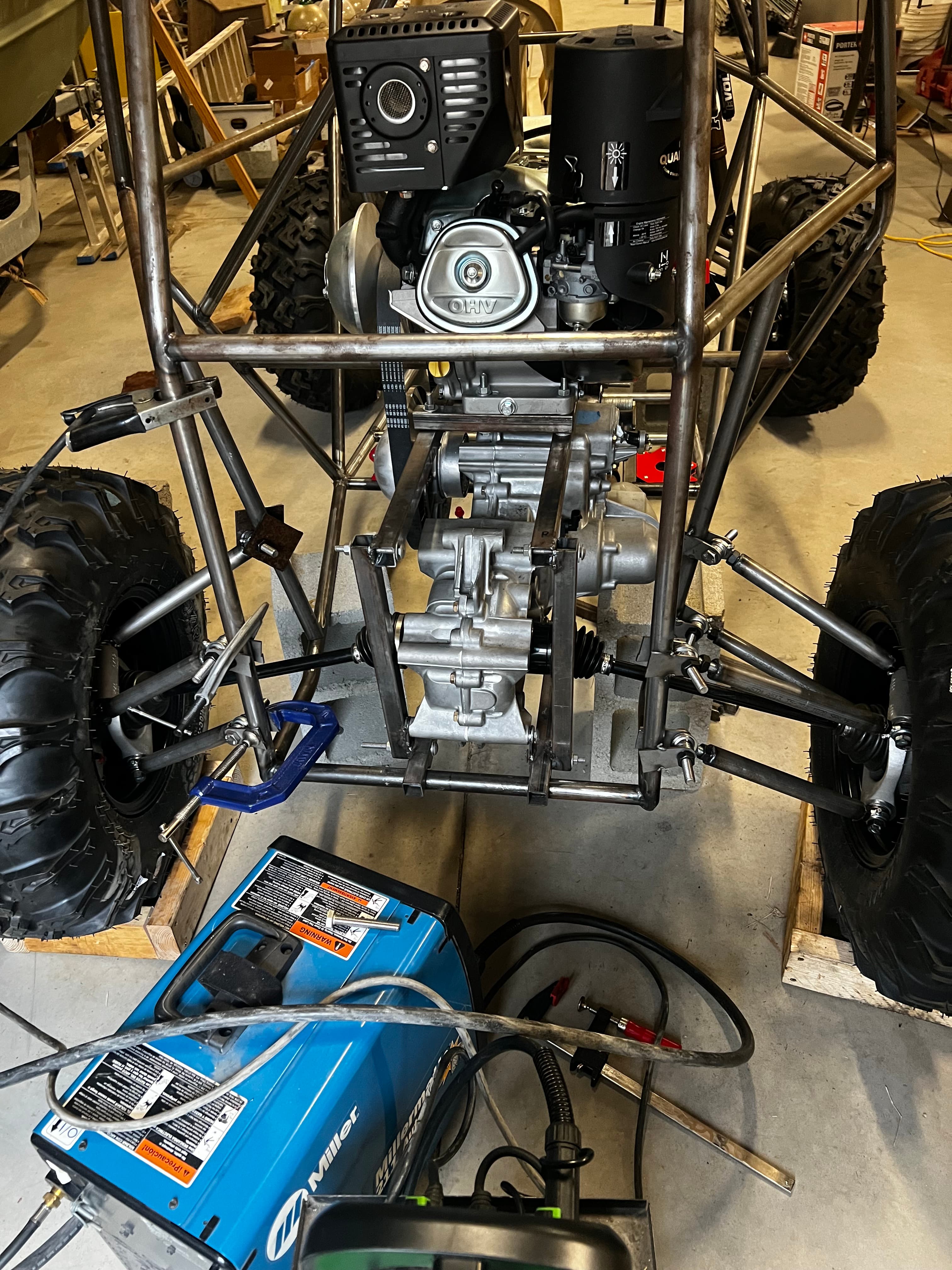 Overhead angle of vehicle with Miller welder in foreground and engine and drivetrain visible